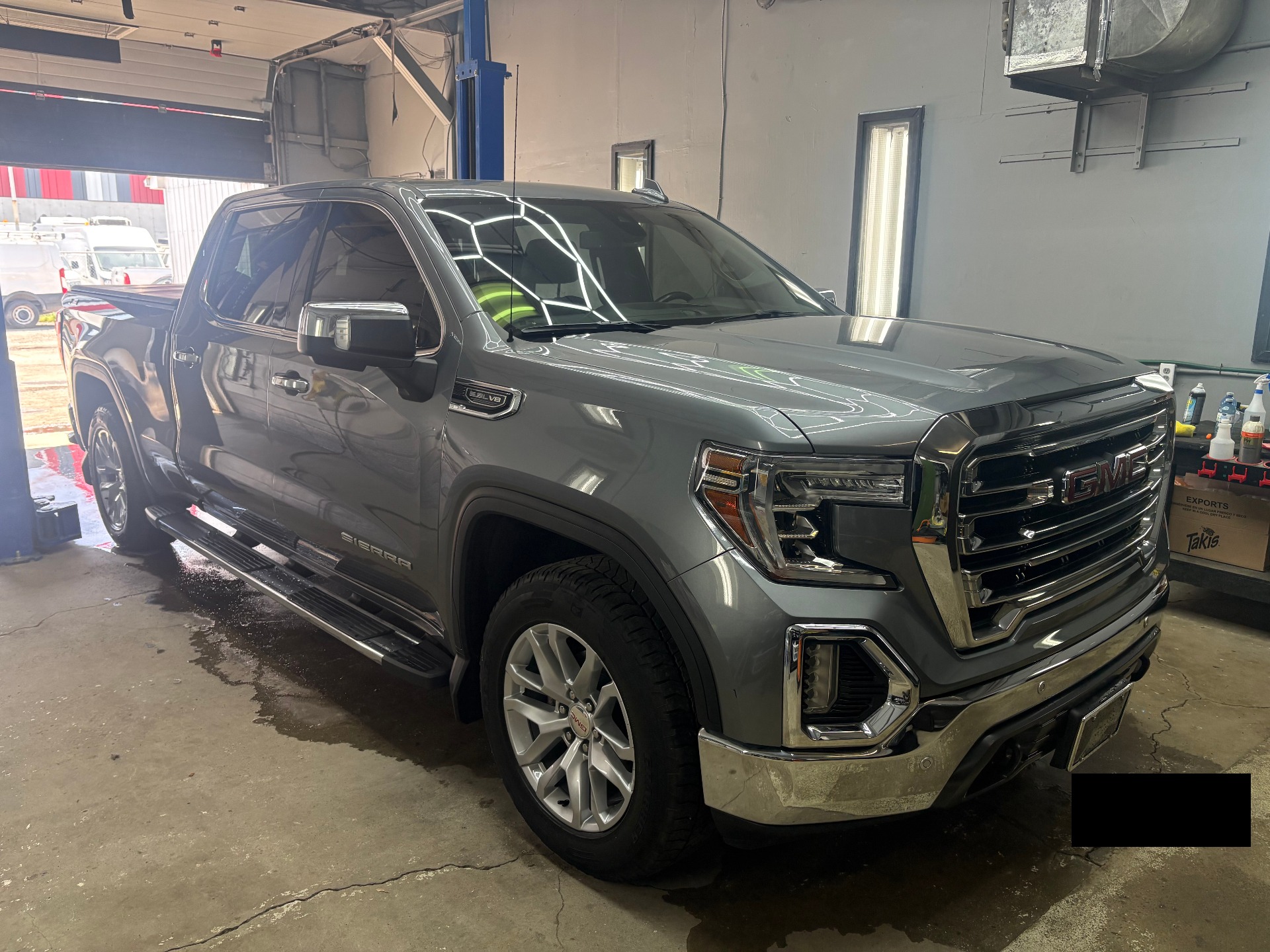Grey GMC Sierra SLT passenger-side front three-quarter after detail